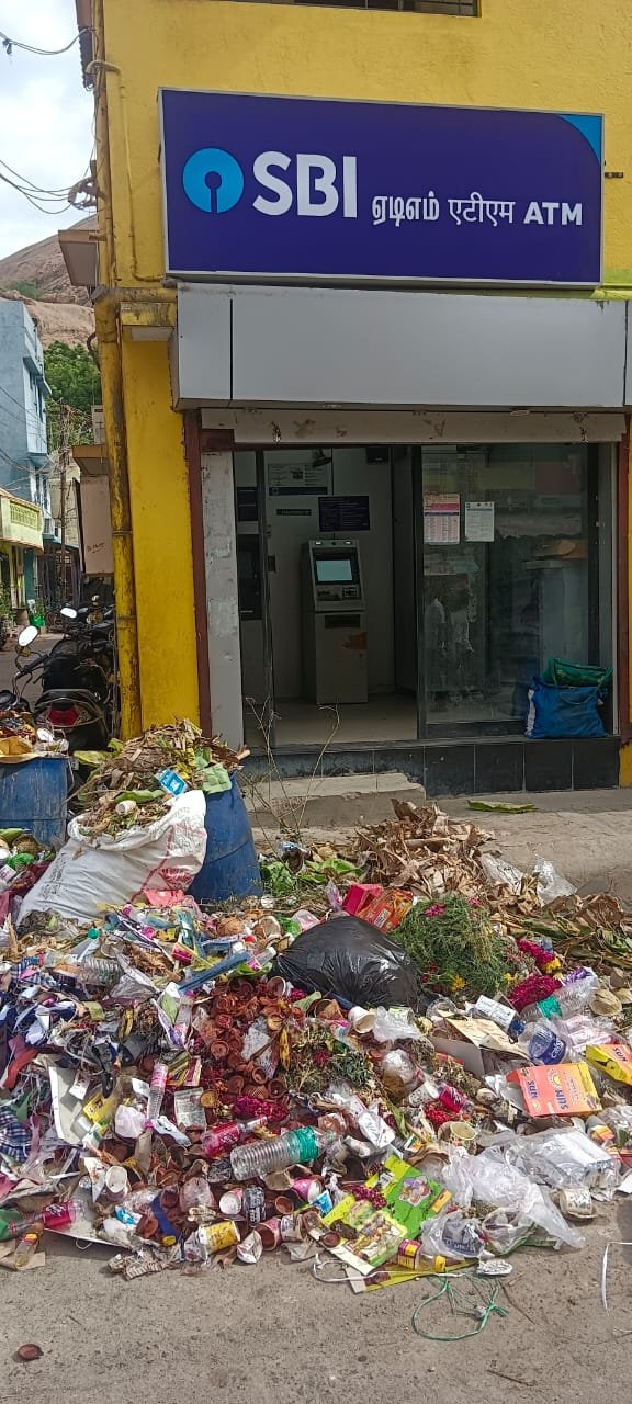 திருப்பரங்குன்றம் முருகன் கோவில் முன்பு கொட்டப்பட்ட குப்பை.