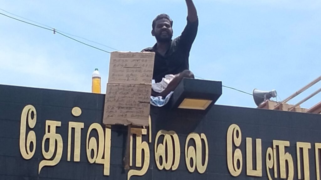 வாடிப்பட்டியில் பேருந்து நிலையத்தின் நுழைவு வாயில் மீது ஏறி கையில் பெட்ரோல் கேனுடன் தற்கொலை மிரட்டல் விடும் ஆட்டோ ஓட்டுனர் போலீசார் தொடர்ந்து பேச்சுவார்த்தை